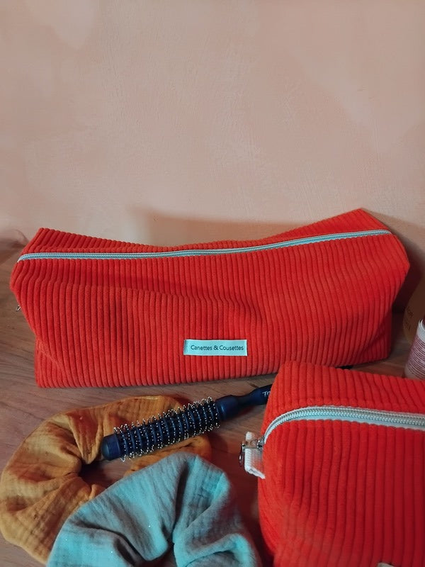 Une trousse grande et spacieuse, de dimensions 36 X 12 X 12, de couleur orange.